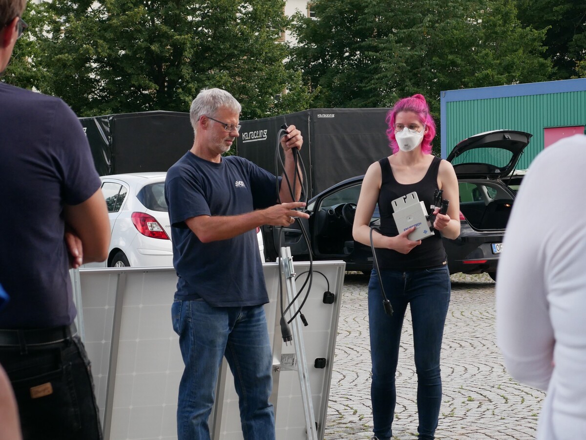 Projektmitarbeiterinnen und -mitarbeiter demonstrieren die Funktion eines Solarpanels.